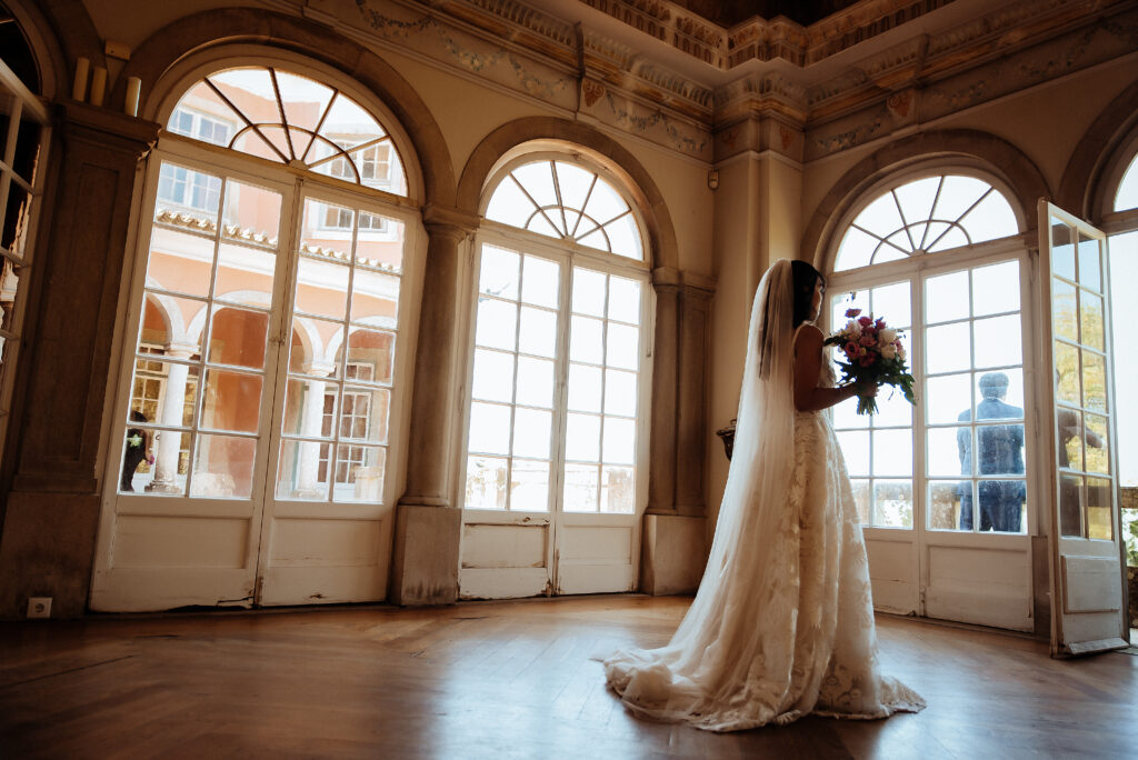 Bride standing inside Casa dos Penedos during a wedding in Sintra overlooking the gardens