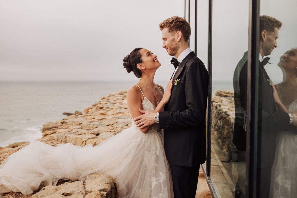 Bride and groom by the sea at an elegant destination wedding in Lisbon
