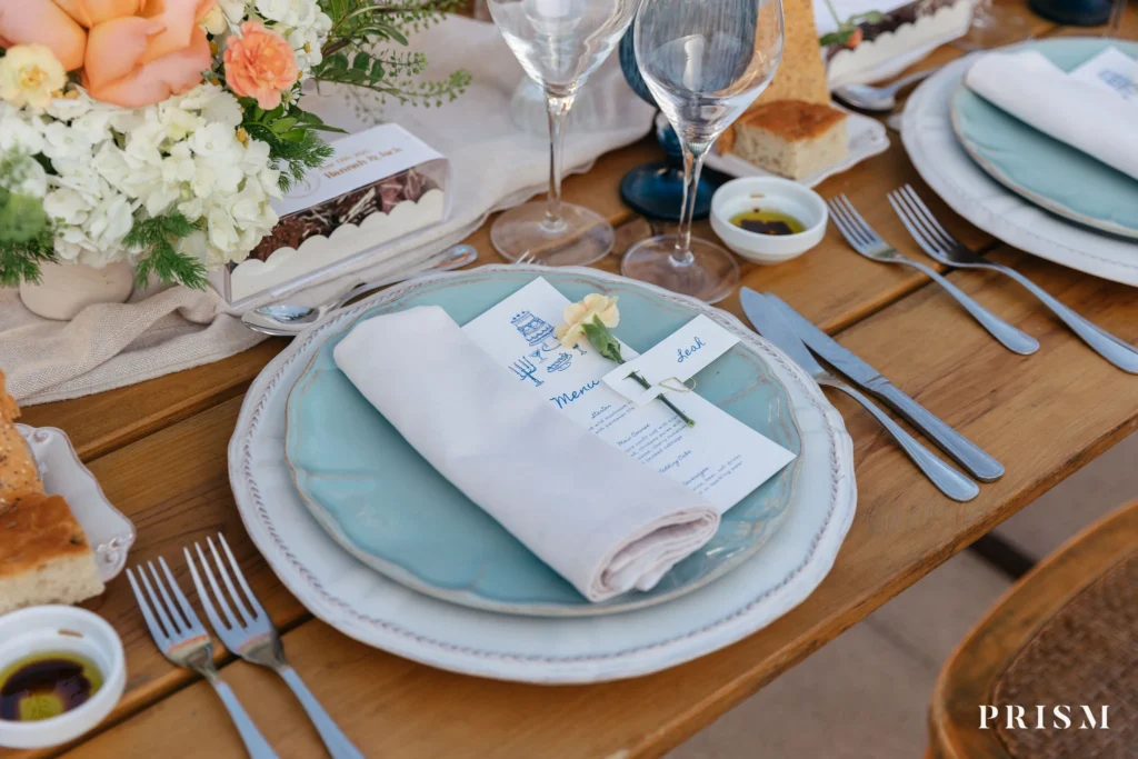 Elegant wedding table setting with menu, florals and fine tableware at a destination wedding in Portugal