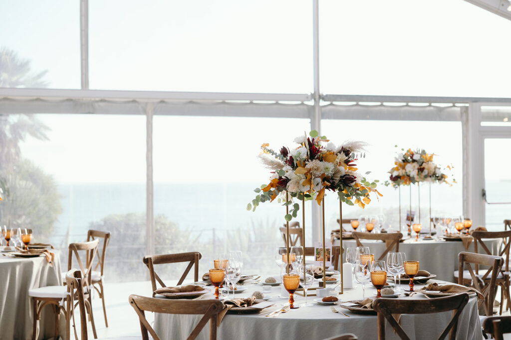Intimate wedding reception setup in Sintra with floral centrepieces and ocean view.