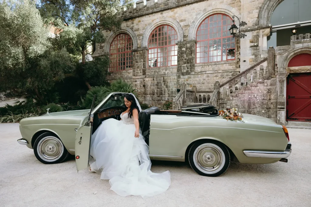 Bride arriving in a classic car at a historic venue during a destination wedding in Portugal