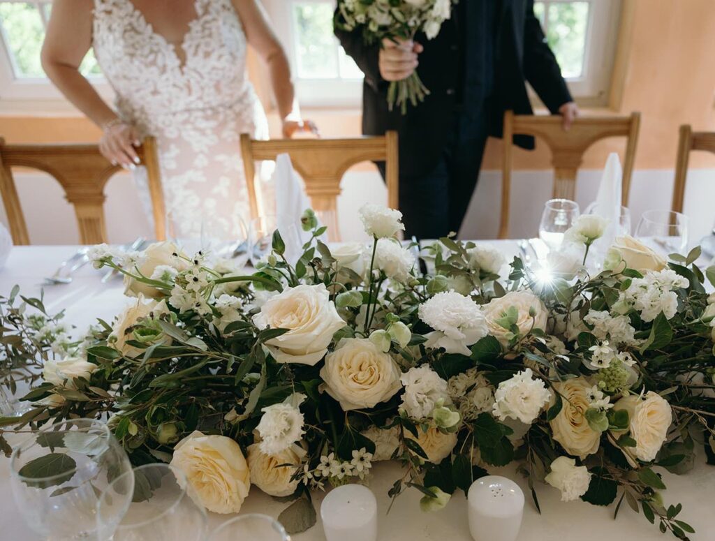 Wedding table setup in Portugal with floral arrangement and couple preparing reception details