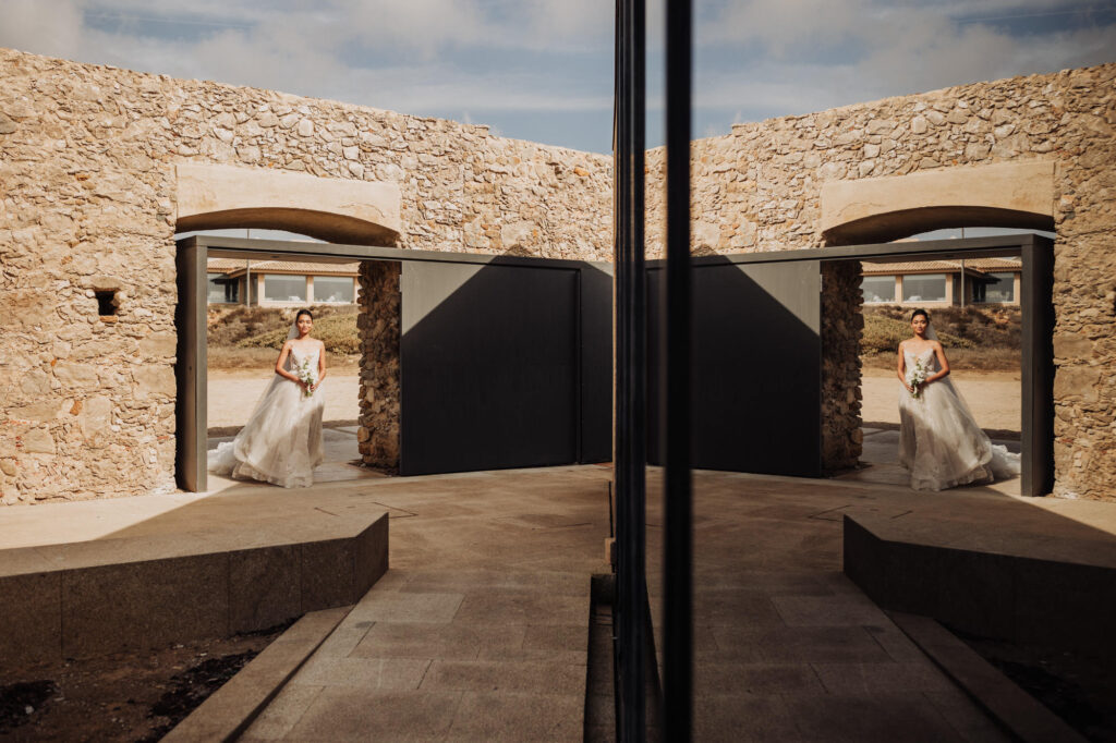 Bride walking through modern stone architecture venue in Cascais during a destination wedding in Portugal