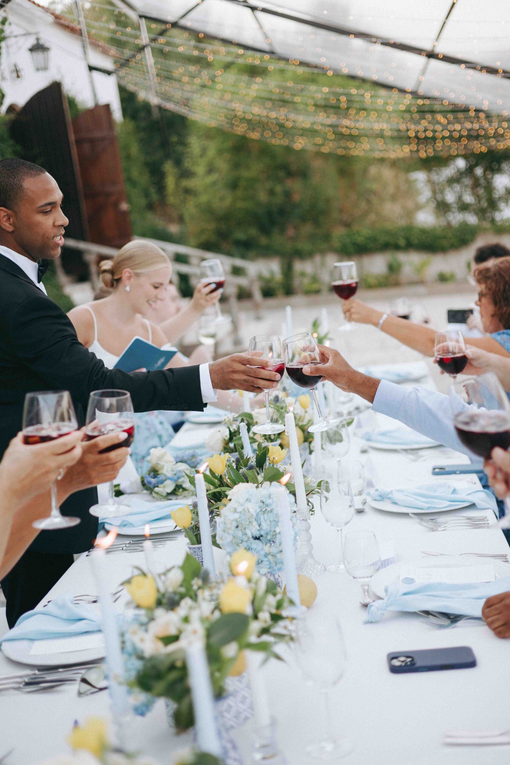 Guests toasting during an outdoor destination wedding dinner in Portugal