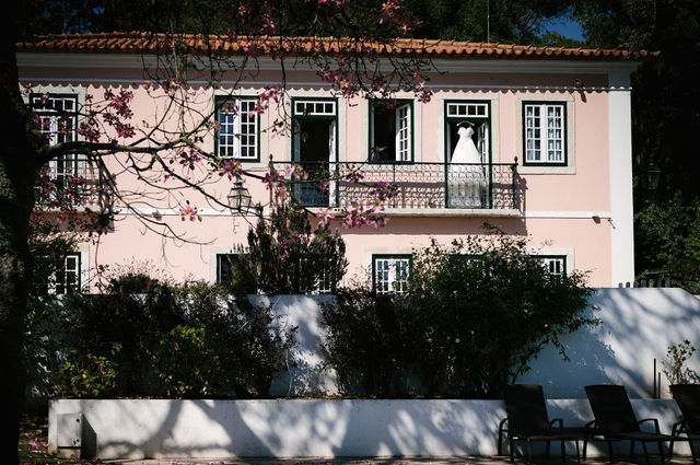 Bride standing on the balcony of a historic estate in Portugal before a destination wedding ceremony