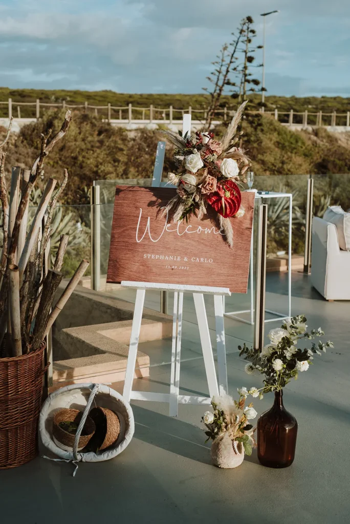 Wedding welcome sign and floral arrangement at a coastal wedding venue in Portugal
