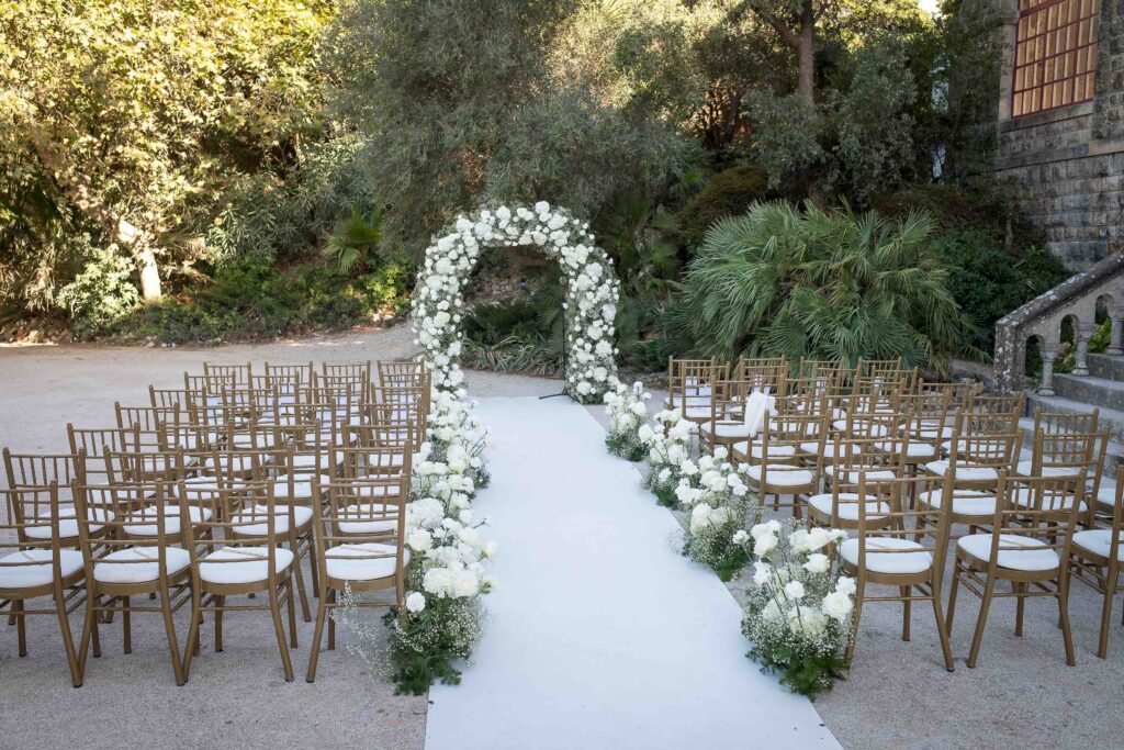 Wedding ceremony setup at Forte da Cruz in Estoril, Portugal, with floral aisle and outdoor seating