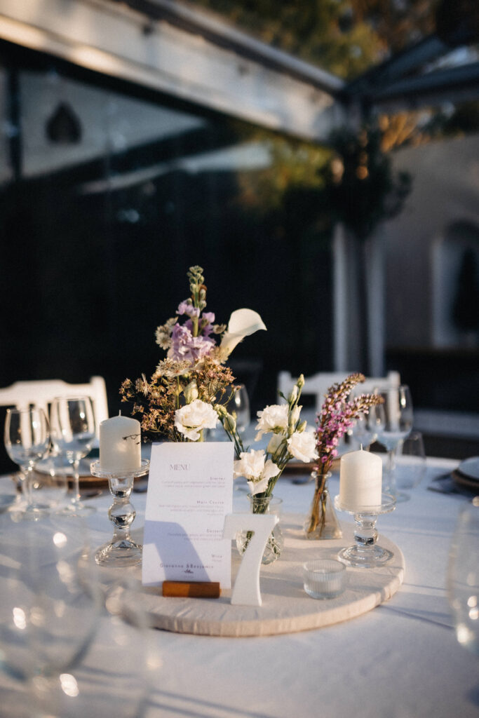 Wedding table with floral arrangements, candles and personalised menu in Portugal