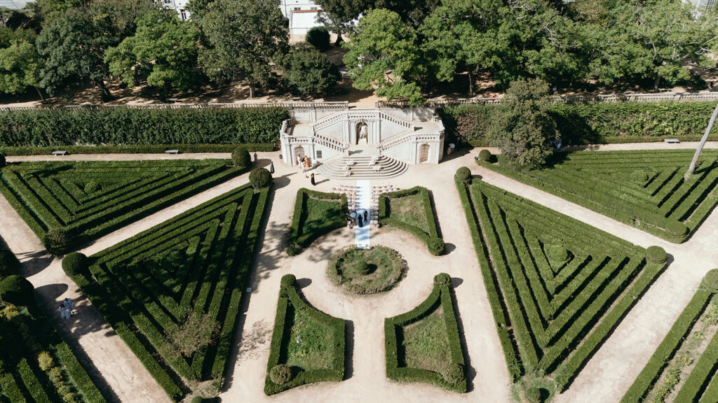 Aerial view of an outdoor wedding ceremony setup at Vandelli, with formal hedges, garden paths and a stone staircase.